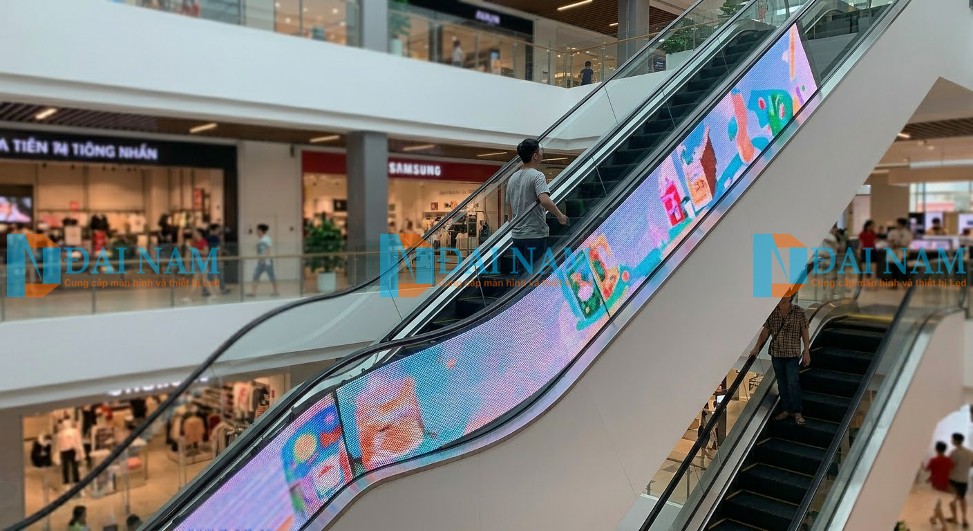 Màn hình LED cong độc đáo được ốp vào vách thang cuốn trung tâm thương mại thu hút sự chú ý của khách hàng.