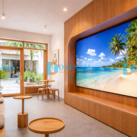 Một màn hình LED Indoor P2 cỡ nhỏ (khoảng 100 inch), hiển thị hình ảnh nghệ thuật tinh tế về thiên nhiên, được tích hợp vào bức tường của một quán cafe nhỏ, ấm cúng có diện tích khoảng 50m2 tại Việt Nam.