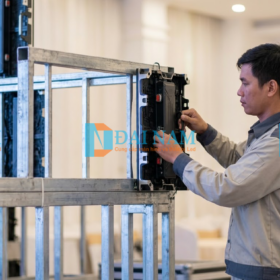 Kỹ thuật viên Đại Nam đang lắp ráp module LED P2.5 có hít nam châm lên khung sắt