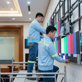 Đội ngũ kỹ thuật viên đang thi công lắp ráp và đấu nối cáp tín hiệu cho tấm LED P5 trên khung sắt.